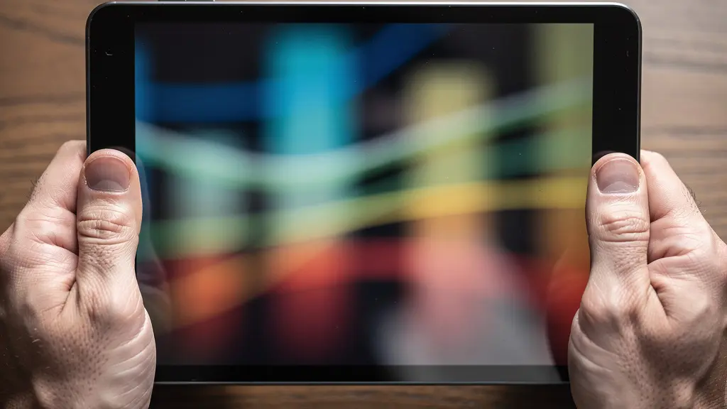 Mains tenant une tablette affichant des graphiques financiers colorés dans un environnement de bureau